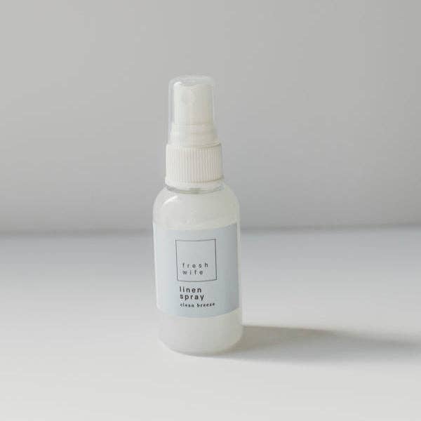 White spray bottle labeled 'fresh wife linen spray' on a gray background