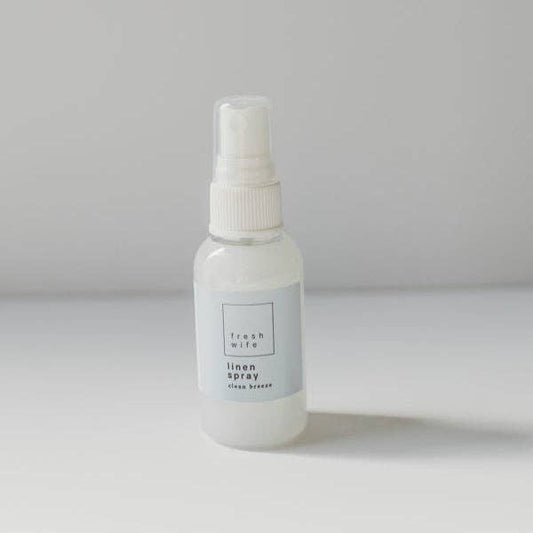 White spray bottle labeled 'fresh wife linen spray' on a gray background
