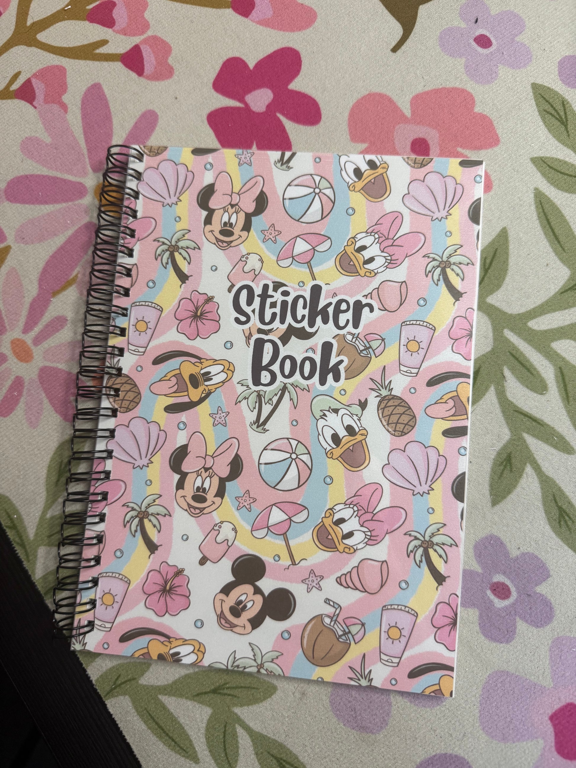 Sticker book with cartoon characters on a floral patterned surface
