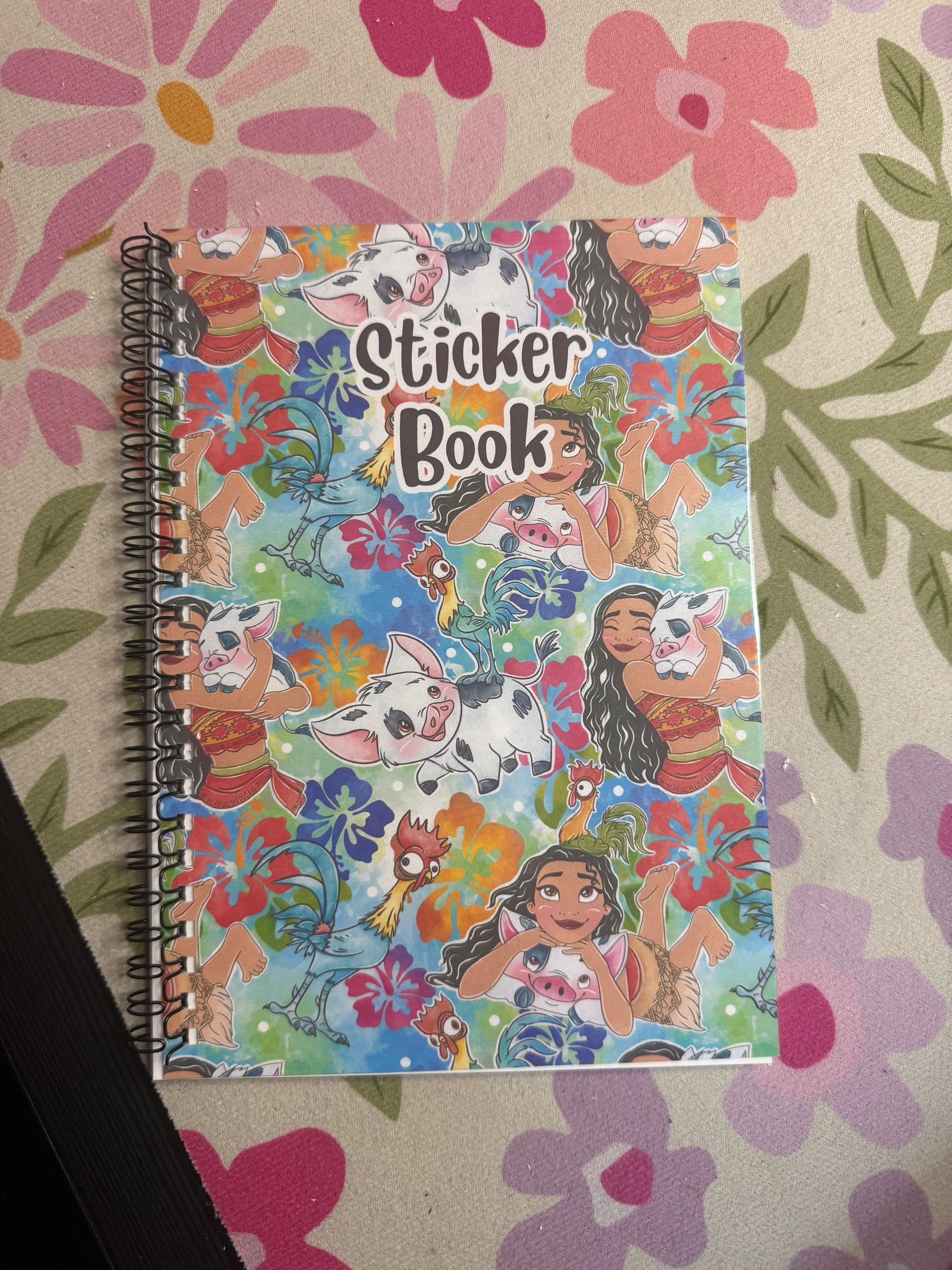 Sticker book with colorful designs on a floral-patterned surface
