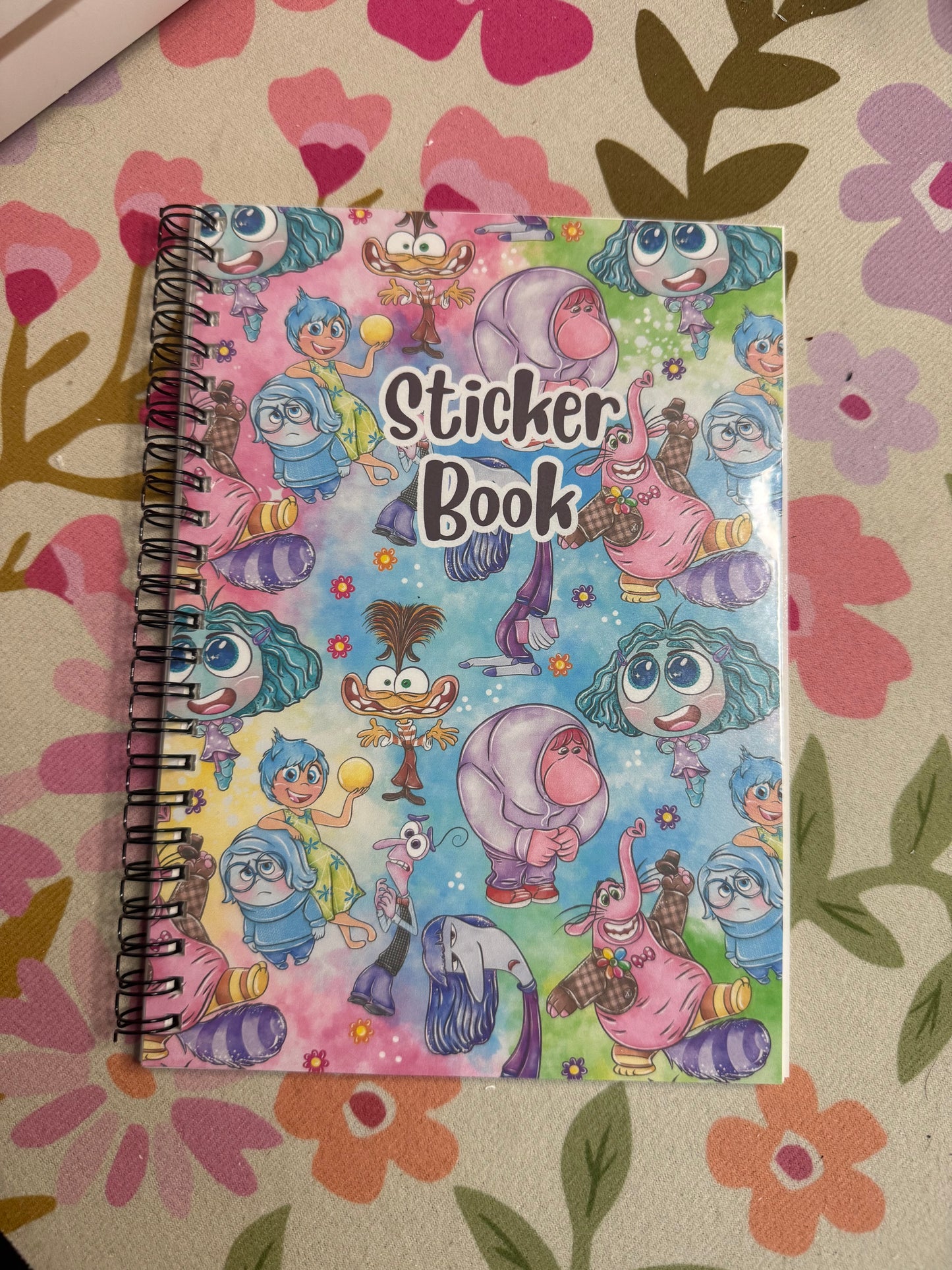 Sticker book with colorful characters on a floral-patterned surface