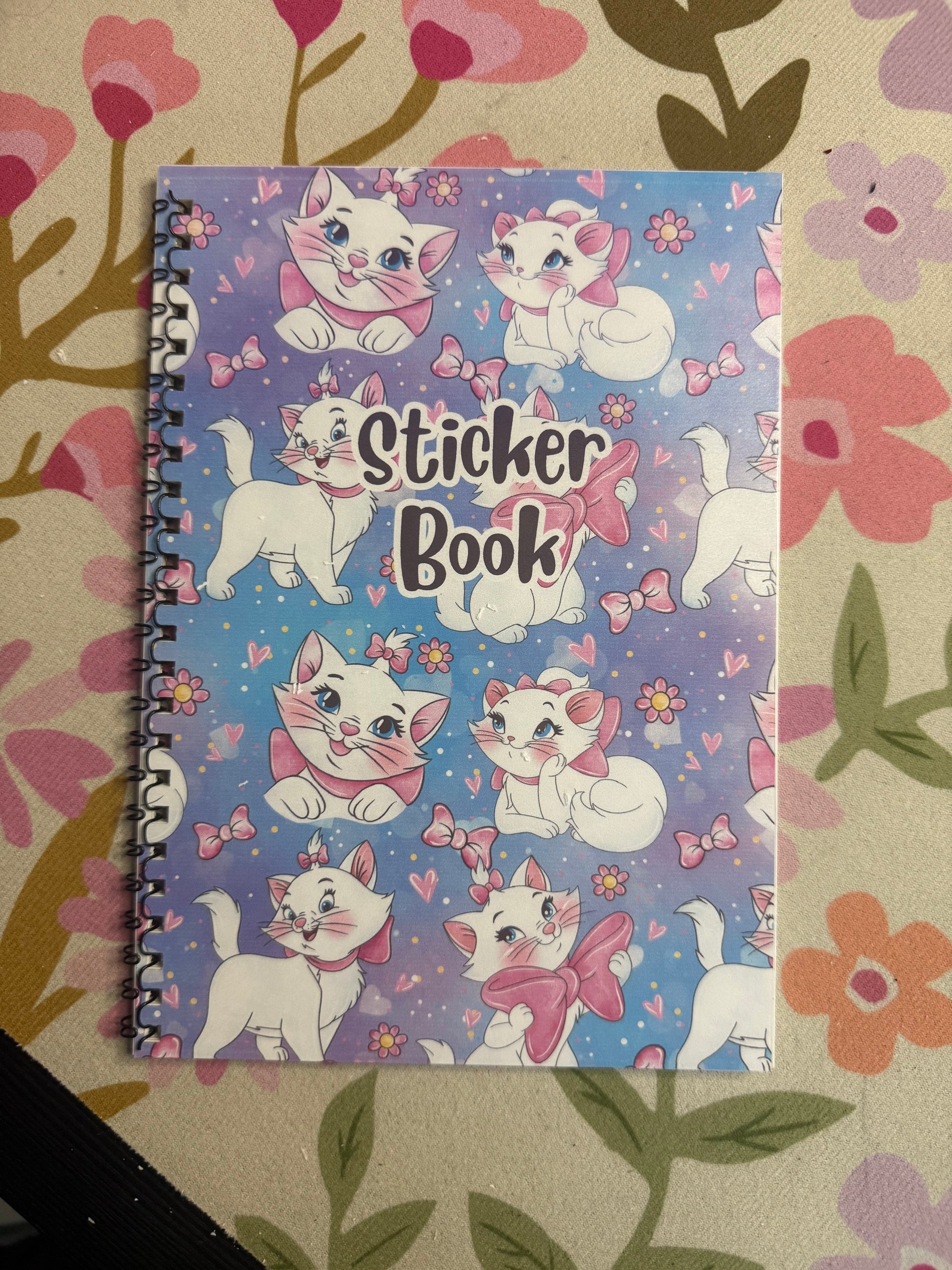 Sticker book with cat illustrations on a floral background